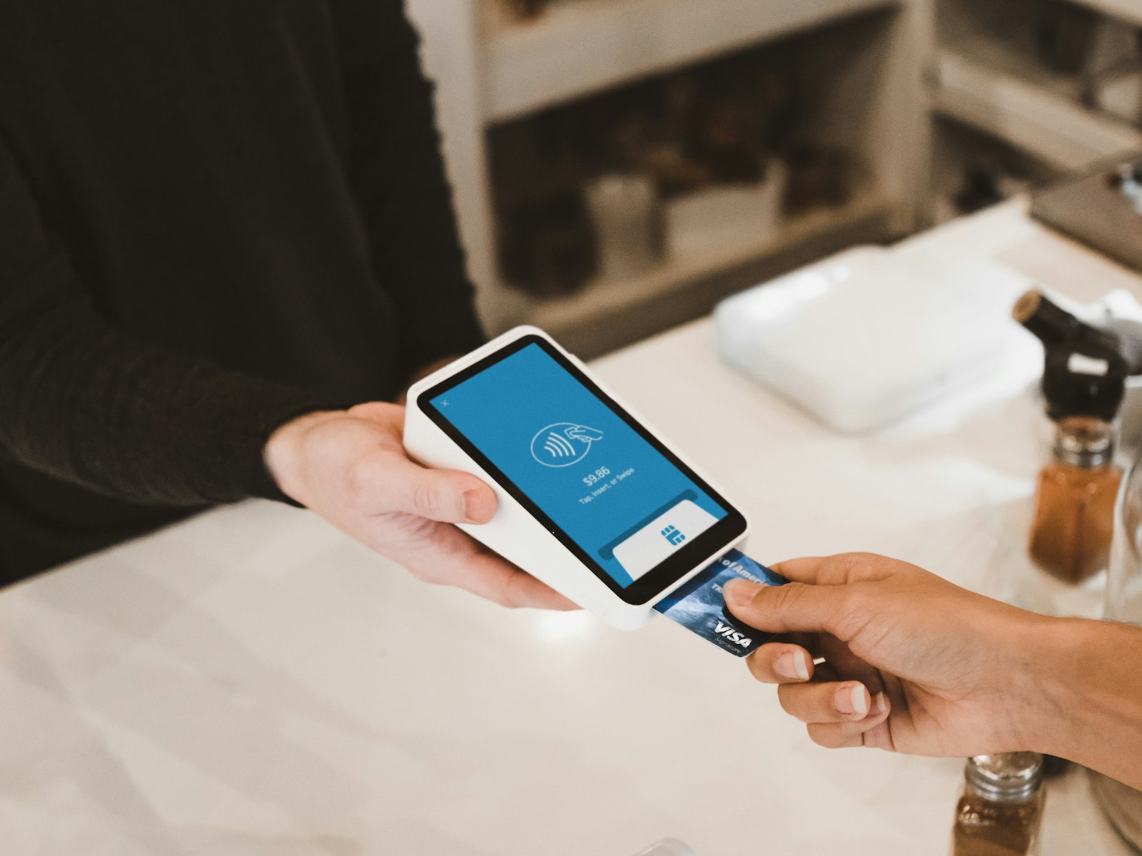 Merchant accepting a contactless card payment on a modern POS terminal